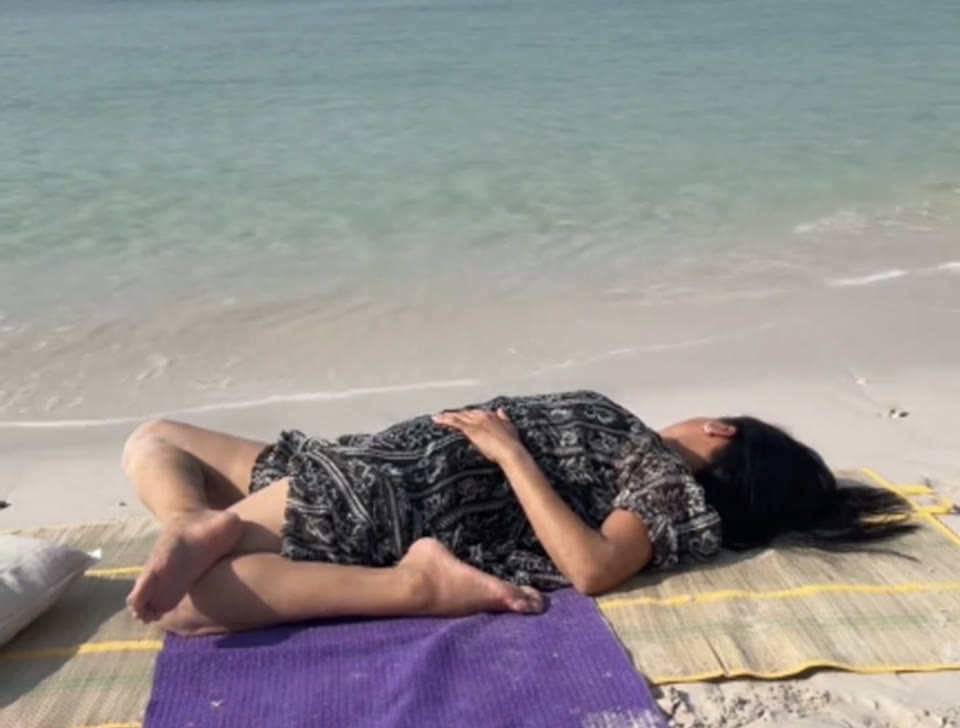 Restful twist on the sand beside the water