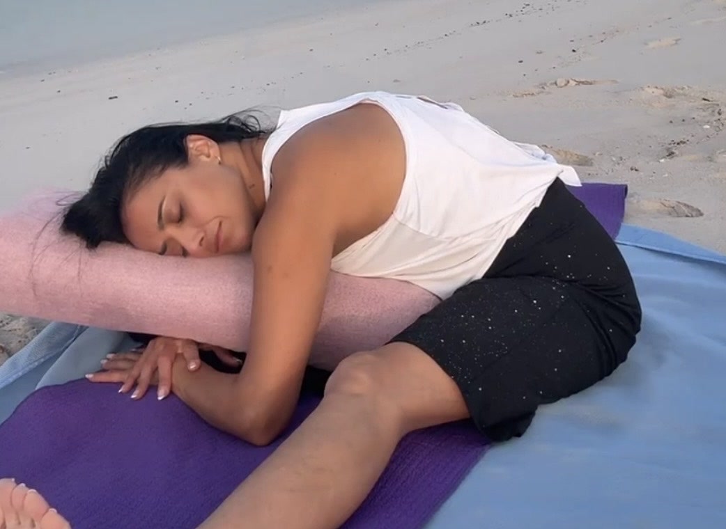 Allya resting in a yin yoga pose on Bay Residences Beach